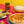 A jar of Sauce Shop Special Makhani Simmer Sauce with a bowl of rice, chickpea curry and naan bread on a pink and yellow background